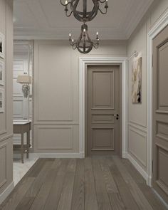 an empty room with a chandelier hanging from the ceiling and wooden flooring