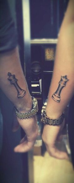 two people with tattoos on their legs holding hands and one has a chess piece tattooed on it