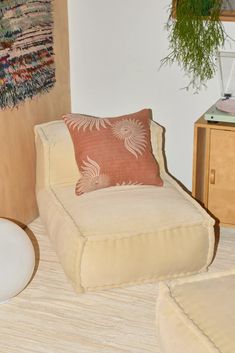 a chair and ottoman in a room with a plant on the wall next to it