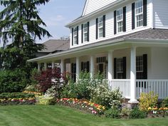 a white house with lots of flowers in the front yard