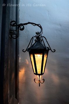 an old fashioned light hanging on the side of a building with no one in it