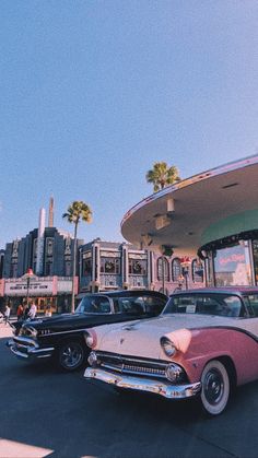 several classic cars parked in front of a gas station