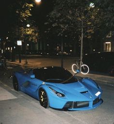 a blue sports car is parked on the street