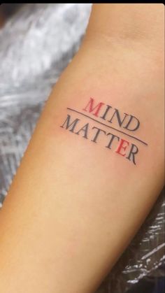 a woman's arm with the word mind matter tattooed on her left arm, in red and black