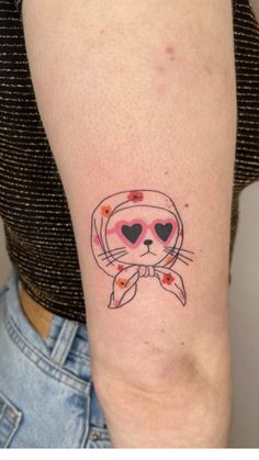 a woman's arm with a cat tattoo on the left side of her arm