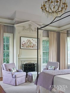 a bedroom with a canopy bed, chair and fireplace