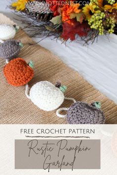 three crocheted pumpkins sitting on top of a table next to a fall wreath