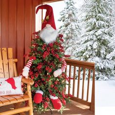 a christmas tree on a porch decorated with santa claus