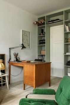 a green chair sitting in front of a wooden desk