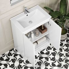 a white sink sitting under a bathroom mirror next to a black and white tile floor