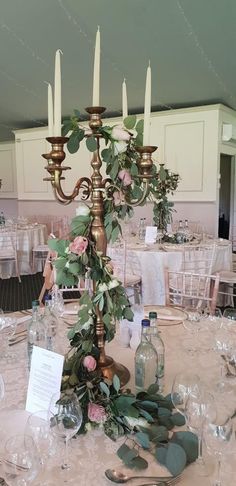 a table set up for a formal function with flowers and candles