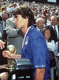 tennis player shaking hands with the trophy in front of an audience