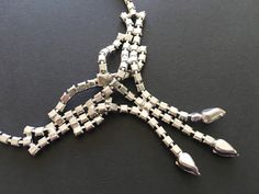 "Beautiful necklace signed Ledo - a company that created high quality jewelry during the 1950s. This necklace features a bow shaped centerpiece with tassels ending in pear shaped rhinestones. Great for a wedding or special occasion, this necklace has an elegant, well made feel. CONDITION/SIZE: In like new condition. This is a small necklace - just under 15\" long. Definitely choker length. LINKS: Looking for a VINTAGE NECKLACE, but this isn't the one? I have more here: https://etsy.me/2WVkYTs Lo Vintage Rhinestone Jewelry For Formal Occasions, Vintage Formal Jewelry With Rhinestones, Vintage Silver Jewelry For Party, Silver Retro Jewelry For Party, Silver Vintage Jewelry For Party, Retro Silver Jewelry For Party, Retro Rhinestone Jewelry For Gifts, Vintage Hand-set Jewelry For Formal Occasions, Vintage Hand Set Evening Jewelry