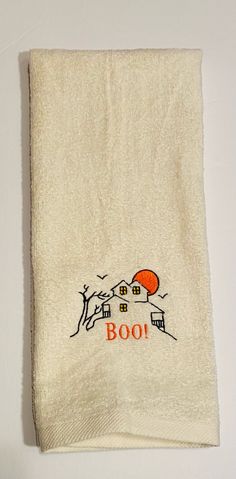 a white towel with an orange house on it and the word boo written in red