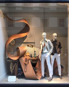 two mannequins dressed in white pants and jackets stand next to each other