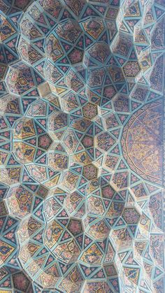 an intricately designed ceiling in the middle of a building with many colors and designs on it