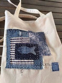 a tote bag made out of old jeans with fish on the front and american flag in the back