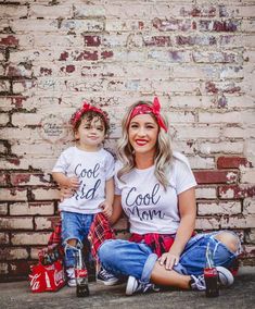 a woman sitting next to a child wearing matching shirts