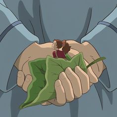 a person holding a green leaf in their hands