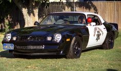 a black and white police car parked in the grass