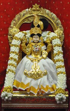 the statue is decorated with gold and white flowers