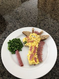 a white plate topped with food on top of a marble counter next to a green plant