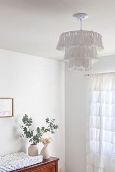 a baby crib in the corner of a room with a window and white curtains