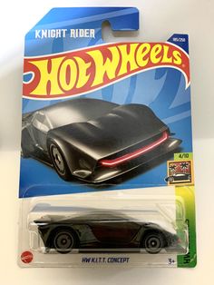 a black hot wheels car is shown in the packaging for this toy vehicle, it has a red light on its hood