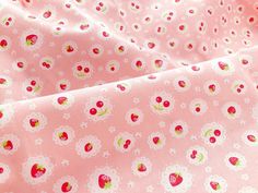 a pink fabric with strawberrys and daisies on it