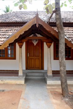 a white house with wooden doors and pillars