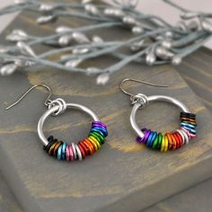 Hoop earrings in the colors of the Progress Pride flag. Choose from mismatched set (with one earring in colors of rainbow pride and the second with the additional colors) or mirror image set (with all colors on each earring).🌈 lightweight & comfortable to wear - each earring weighs about 2 grams (less than the weight of a US dime)🌈 about 1.5" long, including earwire🌈 the colorful links aren't glued down, so you can feel free to fidget with them between your fingertips; they can slide up and d Hypoallergenic Rainbow Hoop Earrings As Gift, Rainbow Nickel-free Dangle Hoop Earrings, Nickel-free Rainbow Dangle Hoop Earrings, Rainbow Small Hoop Earrings, Multicolor Small Hoop Metal Earrings, Rainbow Hypoallergenic Hoop Earrings, Hypoallergenic Rainbow Hoop Earrings, Rainbow Hoop Earrings For Pierced Ears, Small Rainbow Hoop Earrings For Pierced Ears