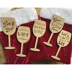 three wooden wine glasses are sitting next to each other on a red velvet blanket with santa's hat in the background