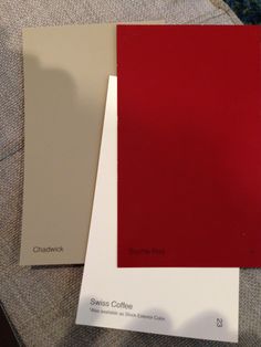 some red and white paint samples sitting on top of each other in front of a couch