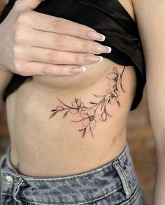 a woman's stomach with flowers on it and her hand resting on the side