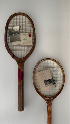 two tennis racquets are hanging on the wall next to each other,