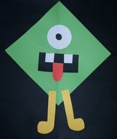 a paper cut out of a green square with eyes, legs and tongue sticking out