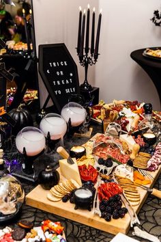 a table topped with lots of different types of food and candles on top of it