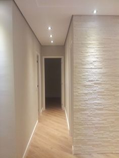 an empty hallway with white walls and wood floors in the center is seen on instagram