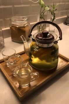 a tea pot and two glasses on a tray