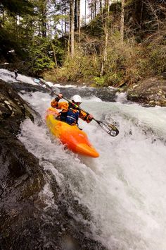 a man in an orange kayak on a river