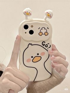 a woman holding up a phone case with an image of a chicken on it