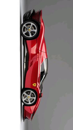 a red sports car hanging from the side of a pole