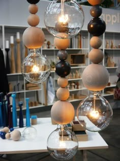 a table topped with lots of hanging glass globes filled with lightbulbs