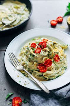 a white plate topped with pasta and tomatoes