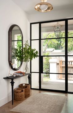 a living room with a large mirror and plants