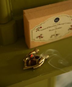 a close up of a small metal object on a green table with a box in the background