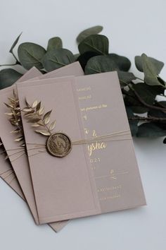 three wedding cards with wax stamp and greenery