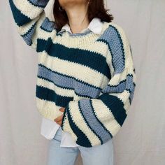 a woman is wearing a sweater with stripes on it and she has her eyes closed