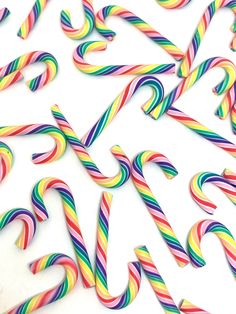 many different colored candy canes on a white surface