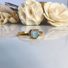 a close up of a ring on a table with flowers in the background and white roses